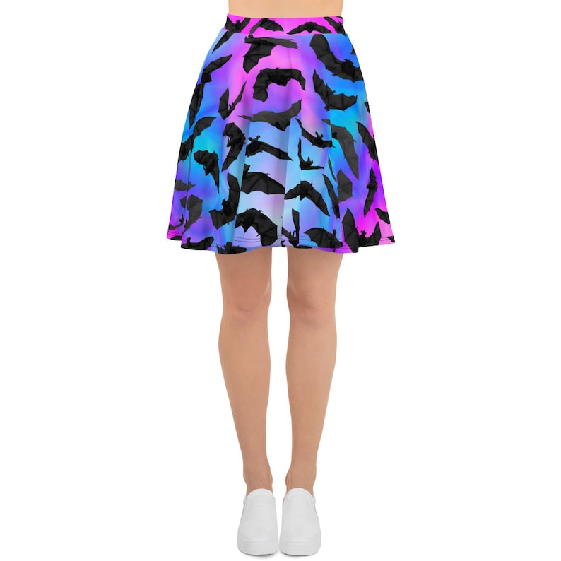 May include: A skater skirt with a colorful ombre pattern of pink, blue, and purple. The skirt is covered in black bat silhouettes.