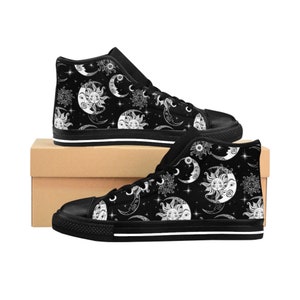 May include: Black high-top canvas shoes with a white sun and moon pattern. The shoes have a white stripe around the sole.