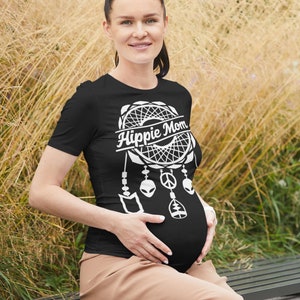 Może przedstawiać: Czarny T-shirt z białym wzorem łapacza sn&oacute;w i napisem "Hippie Mom". Łapacz sn&oacute;w ma znak pokoju, stylizowanego kosmitę i drzewo życia zwisające z niego.