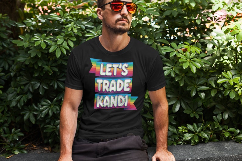 May include: A black t-shirt with the text "Let's Trade KANDI" in rainbow letters on a banner.