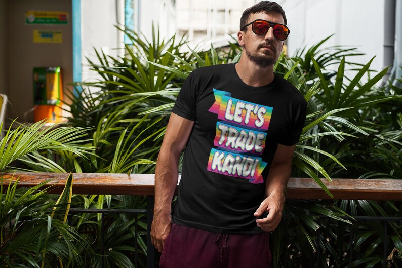 May include: A black t-shirt with a rainbow-colored graphic that says "Let's Trade Kandi".