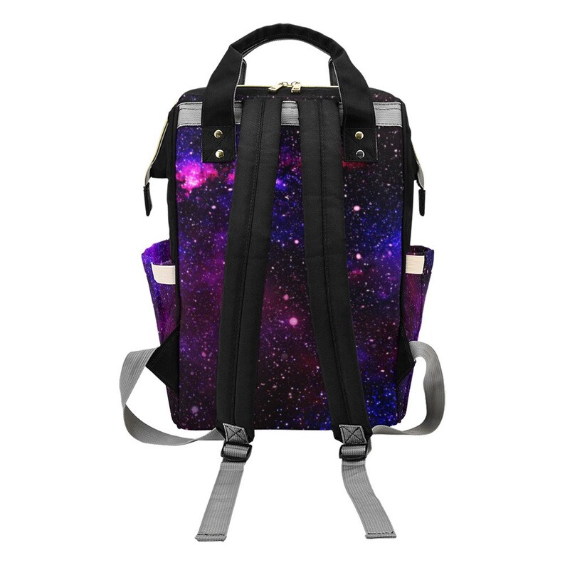 Pode incluir: Uma mochila preta com estampa de gal&aacute;xia em tons de roxo, rosa e azul. A mochila tem al&ccedil;as ajust&aacute;veis e fecho de z&iacute;per.