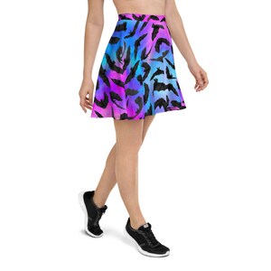 May include: A skater skirt with a colorful ombre pattern of pink, blue, and purple. The skirt is covered in a repeating pattern of black bat silhouettes.
