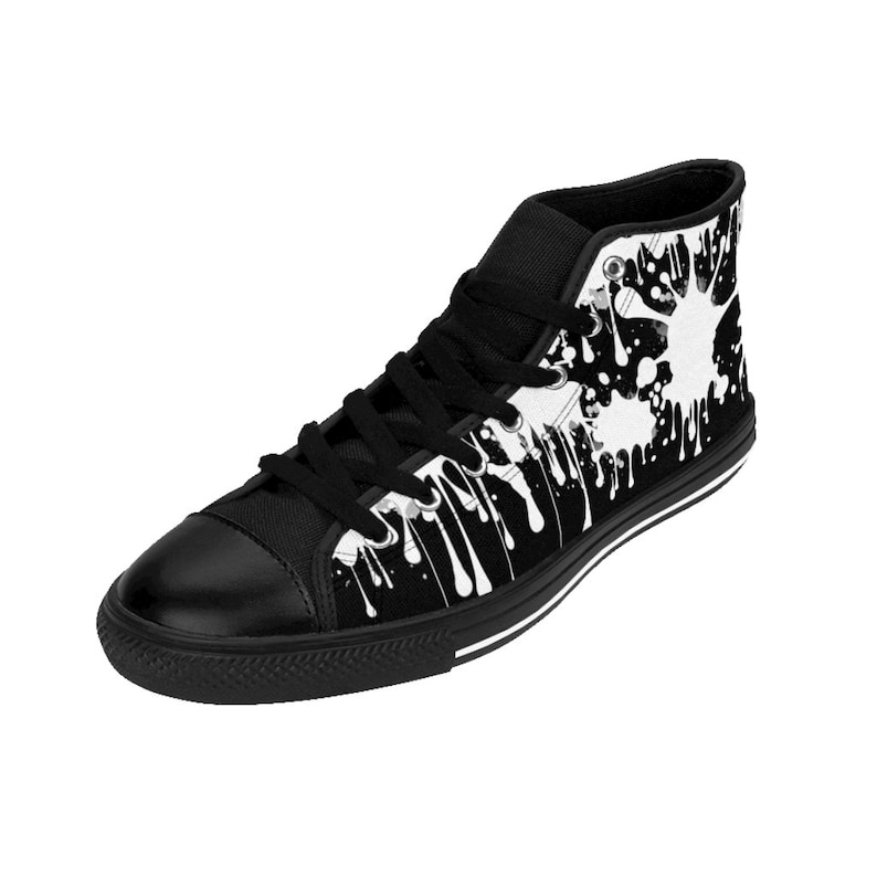 May include: Black high-top canvas sneakers with a white paint splatter design. The paint drips down the sides of the shoe.