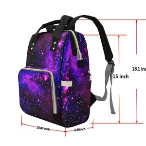 Pode incluir: Mochila de fraldas de cor roxa e preta com estampa de gal&aacute;xia e detalhes de z&iacute;per dourados. A mochila mede 46 cm de altura, 38 cm de largura, 27,5 cm de comprimento e 17 cm de profundidade.