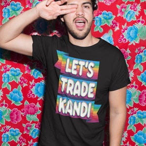 May include: A black t-shirt with a rainbow-colored banner that says "Let's Trade Kandi".