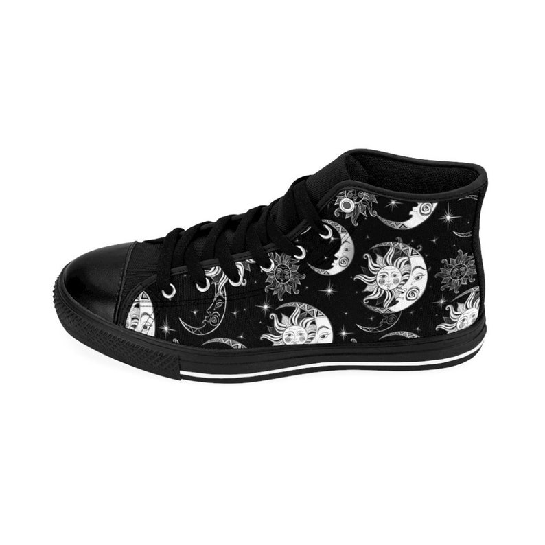 May include: Black high-top canvas shoes with a white celestial pattern of moons and suns on a black background.