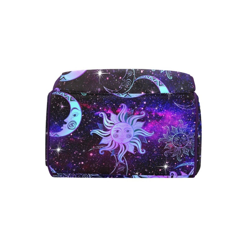 May include: Purple backpack with a galaxy print featuring moons and suns with faces. The background is a dark purple with pink and blue accents.