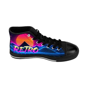 Puede incluir: Una zapatilla alta negra con un estampado gr&aacute;fico vibrante de un atardecer de ne&oacute;n sobre un paisaje monta&ntilde;oso de rejilla azul. La palabra RETRO aparece en una fuente colorida y estilizada en el lateral. El calzado tiene cordones y puntera negros.