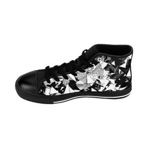 May include: Black and white high-top canvas sneakers with a geometric pattern. The shoes have a black rubber sole and white laces.