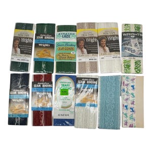 Könnte beinhalten: Sortiment von Wrights-Marken-Saumbändern und Saumklebebändern in verschiedenen Farben und Mustern, darunter Grün, Beige, Weiß, Marine, Rot und Blau. Die Verpackung zeigt das Wrights-Logo und Produktbeschreibungen.