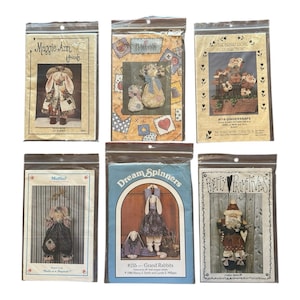 Puede incluir: Seis paquetes de patrones de manualidades en fundas de plástico. Los paquetes presentan ilustraciones de muñecas y conejos de tela. Los títulos incluyen "Maggie Ann", "Plain Jane", "Gingersnaps", "Muffin!", "Dream Spinners" y "Pretty Primitives."