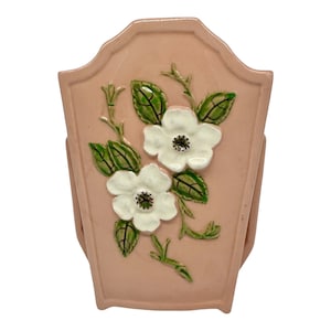 以下が含まれることがあります： 白い花と緑の葉が描かれた装飾的な花のデザインが施されたピンクの陶器の花瓶