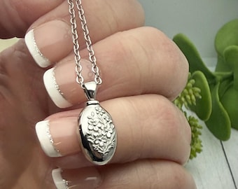 Può includere: Una tazza di ceramica bianca con un manico nero e la scritta "But First, Coffee" in nero, con un carattere a mano. La tazza è su una superficie bianca.