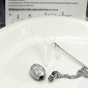 May include: A silver cremation jewelry pendant with a floral design, a small funnel, and a chain. The image includes instructions on how to fill the jewelry, including a list of necessary items.