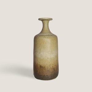 Könnte beinhalten: Eine hohe, handgefertigte Keramikvase mit schmalem Hals und rundem Körper. Die Vase hat eine strukturierte Oberfläche und einen Farbverlauf, der von hellem Beige oben nach Dunkelbraun unten übergeht. Geeignet für die Inneneinrichtung.