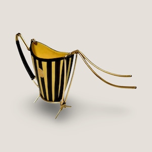 Peut inclure: Seau à glace vintage avec un motif à rayures noires et dorées. Le seau a une monture et une poignée en métal doré, avec une poignée en cuir noir. L'intérieur est jaune. Le seau est soutenu par trois petits pieds.