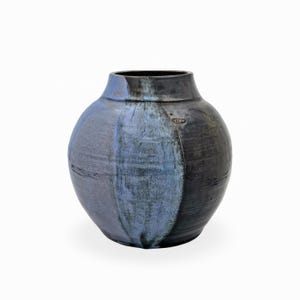 Könnte beinhalten: Eine runde Keramikvase mit bauchigem Körper und engem Hals. Die Oberfläche ist mit einer dunkel anthrazitfarbenen Glasur versehen, mit einem markanten vertikalen Streifen aus hellblauer und grauer Sprenkelglasur in der Mitte. Ein Stempel ist sichtbar.