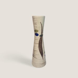 Könnte beinhalten: Eine hohe, schlanke Keramikvase mit cremefarbener Basis und horizontalen, braunen Pinselstrich-Texturen. Die Oberfläche ist mit einer großen, dunkelbraunen blattartigen Form, einem kleinen blauen Oval, einem grünen Oval und dünnen schwarzen Linien verziert.