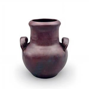 May include: A dark plum-coloured ceramic vase with a rounded body, a wide neck, and two small, curved handles on opposite sides. The surface features a mottled, textured finish with subtle variations in deep purple and black tones throughout.