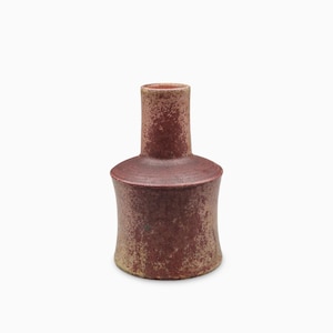 Può includere: Un vaso in ceramica con collo cilindrico e corpo concavo più largo. La superficie presenta una finitura maculata e testurizzata in tonalità di marrone rossastro intenso e beige tenue, creando un aspetto vissuto con colori terrosi.