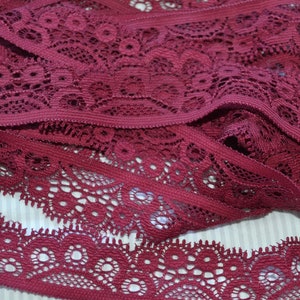 Peut inclure: Galon de dentelle bordeaux avec un motif floral délicat. La dentelle est douce et extensible, idéale pour ajouter une touche d'élégance à tout projet.