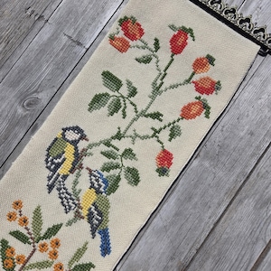 Vintage geborduurde vogelmuurdecoratie: Scandinavische volkskunsttextiel met koperen franje