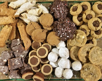 May include: A variety of homemade cookies and treats arranged on a glass platter. The assortment includes biscotti, gingerbread cookies, chocolate-covered cookies with peppermint, peanut butter cookies, and powdered sugar-covered snowball cookies.