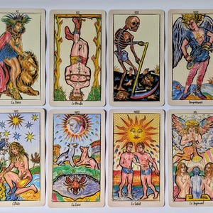 May include: A set of twelve tarot cards arranged in two rows, featuring colorful illustrations of figures and symbols including a skeleton with a scythe, a sun, a devil, and a winged angel, with French text labels at the bottom of each card.