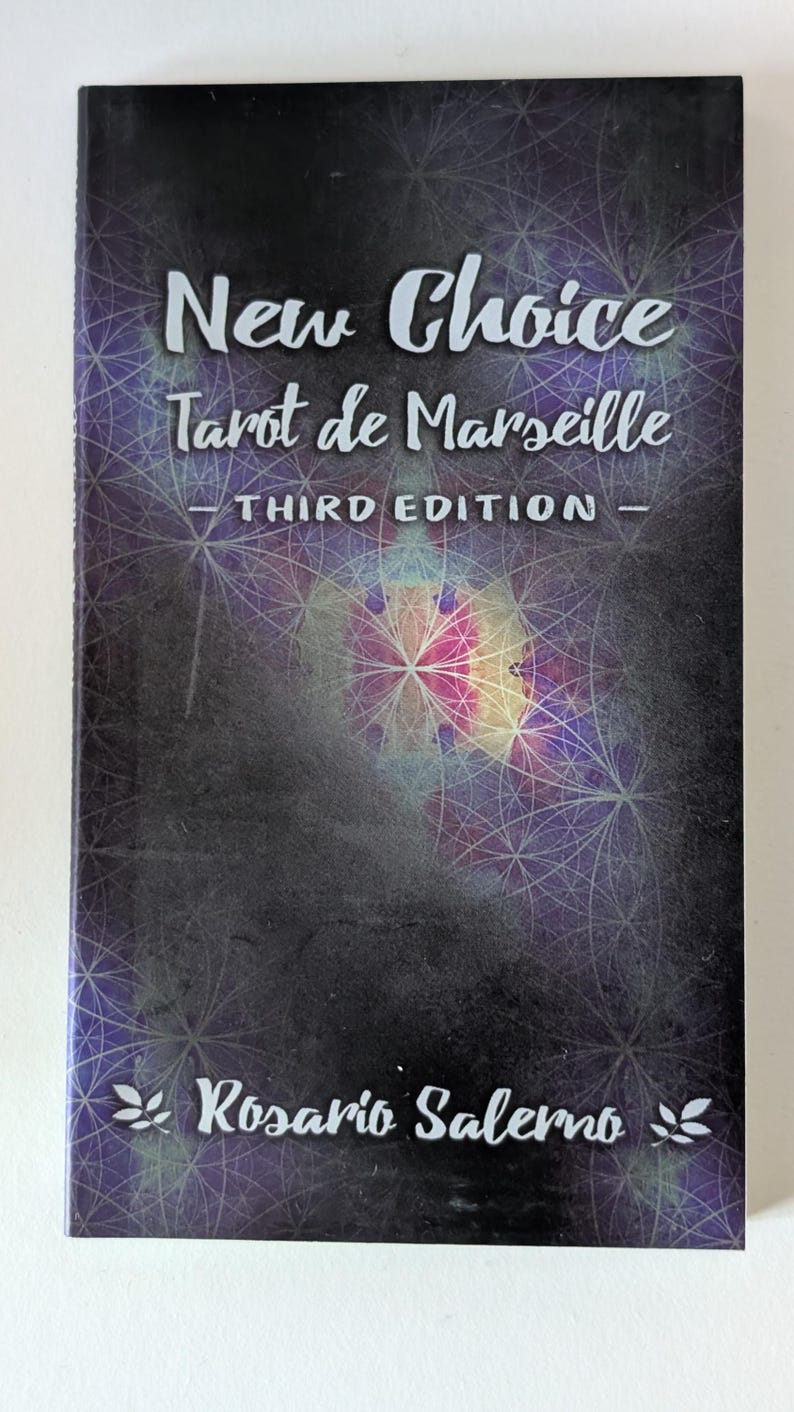 May include: A rectangular book titled New Choice Tarot de Marseille Third Edition by Rosario Salerno. The cover features a dark purple and black background with a white geometric pattern of intersecting circles and a central light burst.