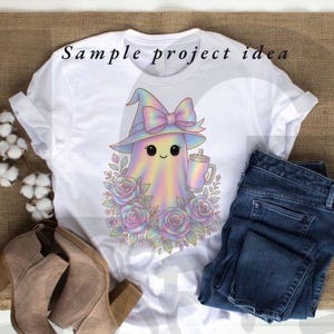 May include: White t-shirt featuring a pastel ghost wearing a witch hat with a bow, holding a drink, and surrounded by roses. The text "Sample project idea" is printed at the top. Paired with blue jeans and tan boots.
