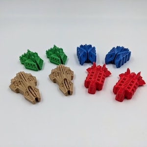 May include: A set of eight miniature spaceships in green, brown, blue, and red. The spaceships are made of plastic and have a detailed design.