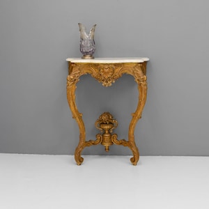 Peut inclure: Une console en bois peinte en or avec un plateau en marbre blanc. La table a un design sculpt&eacute; et un style d&eacute;licat et orn&eacute;.