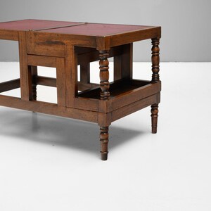 Puede incluir: Una mesa de madera marr&oacute;n oscuro con tapa de cuero rojo. La mesa tiene patas torneadas y un estante inferior. La mesa mide aproximadamente 76 cm de largo, 46 cm de ancho y 51 cm de alto.