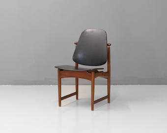 May include: A mid-century modern chair with a dark gray seat and backrest. The chair has a wooden frame with a natural finish. The design features curved armrests and a slightly angled back. The chair is set against a gray background.