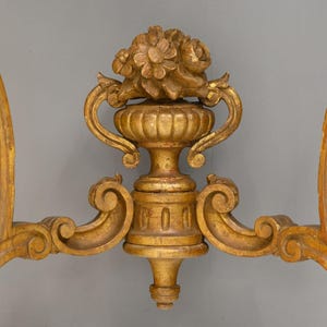 Peut inclure: Une base de table en bois peinte en or avec des sculptures orn&eacute;es et un motif floral. La base est en forme de vase avec deux poign&eacute;es et un dessus rond.