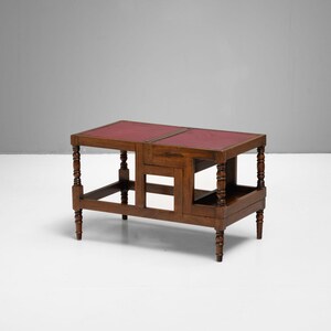 Puede incluir: Una mesa auxiliar de madera oscura con tapa de cuero rojo. La mesa tiene forma rectangular con patas torneadas y un estante inferior. La mesa mide aproximadamente 76 cm de largo, 46 cm de ancho y 61 cm de alto.