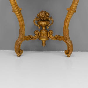 Peut inclure: Une console en bois peinte en or avec des sculptures orn&eacute;es et un fleuron d&eacute;coratif en forme d'urne.