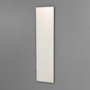 May include: A long, rectangular mirror with a white surface and a black frame. The mirror is mounted on a grey wall, reflecting the surroundings. The design is minimalist and modern.