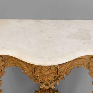 Peut inclure: Une console avec un plateau en marbre blanc et des pieds en bois sculpt&eacute;s et peints en or.