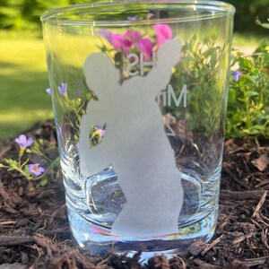 May include: A clear glass tumbler with an etched silhouette of a person playing basketball. The text "HS" and "M" are etched on the glass.