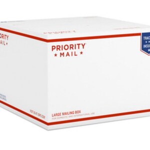 Könnte beinhalten: Ein weißer Priority Mail Karton mit roten und blauen Akzenten. Der Karton ist mit "PRIORITY MAIL" und "TRACKED INSURED" beschriftet. Es ist ein großer Versandkarton für den nationalen und internationalen Gebrauch.