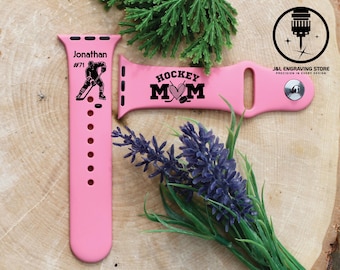 Puede incluir: Banda rosa para Apple Watch con un gráfico negro de un jugador de hockey y el texto "Jonathan #71" en un lado y el texto "Hockey Mom" con un corazón y un palo de hockey en el otro lado.