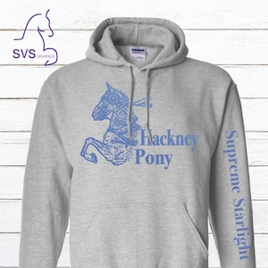May include: Gray hooded sweatshirt with a blue graphic of a horse with the text "Hackney Pony" and "Supreme Starlight" on the sleeve.