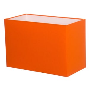 May include: An orange rectangular lampshade made of fabric.