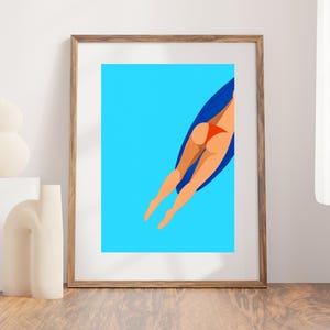 Puede incluir: Una impresión artística enmarcada que presenta una ilustración minimalista de una persona nadando en una piscina. La obra representa a una persona con un traje de baño rojo, con agua azul y una tabla de surf azul.