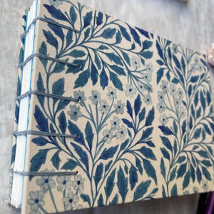 Floral watercolour sketchbook. Coptic binding with 300gsm cold pressed paper. Front and spine view of A6 landscape book.
