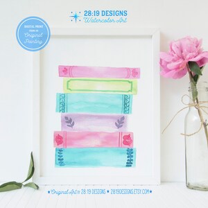 May include: A watercolour painting of a stack of colourful books with decorative details. The painting is framed and has the text "28:19 DESIGNS Watercolor Art" at the top.