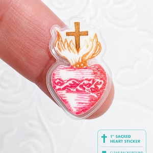 May include: A clear sticker featuring a red heart with a cross and flames. The sticker is approximately 1 inch in size. The heart design has a detailed, hand-drawn appearance. The sticker has a clear background.