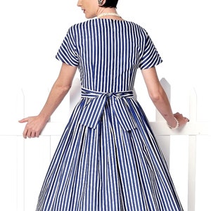 May include: A blue and white striped dress with a fitted bodice and a full skirt. The dress has a tie belt at the waist and short sleeves.